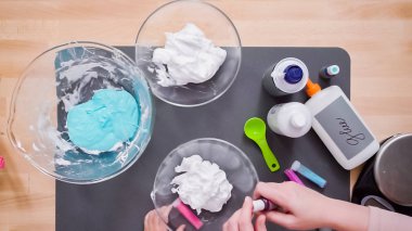 Adım adım. Anne ve kızı renkli kabarık slime yapmak.
