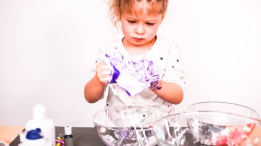 Adım adım. Anne ve kızı renkli kabarık slime yapmak.