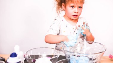 Adım adım. Anne ve kızı renkli kabarık slime yapmak.