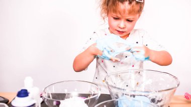 Adım adım. Anne ve kızı renkli kabarık slime yapmak.