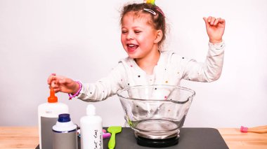 Adım adım. Anne ve kızı renkli kabarık slime yapmak.