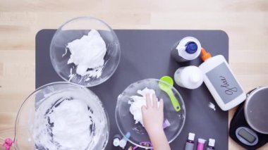 Adım adım. Düz yatıyordu. Anne ve kızı renkli kabarık slime yapmak