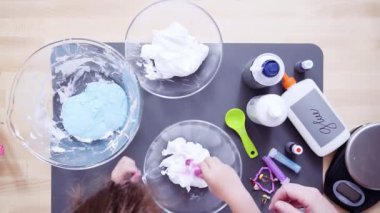 Zaman atlamalı. Adım adım. Düz yatıyordu. Anne ve kızı renkli kabarık slime yapmak