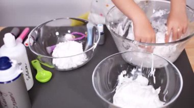 Zaman atlamalı. Adım adım. Anne ve kızı renkli kabarık slime yapmak.