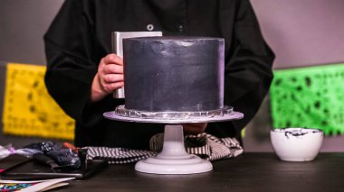 Adım adım. Siyah İtalyan buttercream frosting ile çok katmanlı çikolatalı kek frosting Baker.