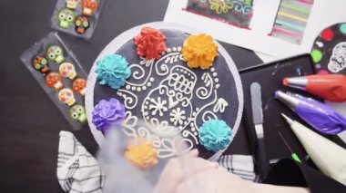 Adım adım. Düz yatıyordu. Dia de los Muertos tatil top bir çok katmanlı kek üzerine krema İtalyan renkli buttercream Boru hattların başka şekilli Baker.