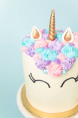 Pembe ve mor mavi arka plan üzerinde buzlanma buttercream ile gurme tek boynuzlu at pasta.