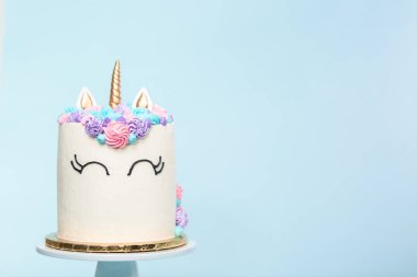Pembe ve mor mavi arka plan üzerinde buzlanma buttercream ile gurme tek boynuzlu at pasta.