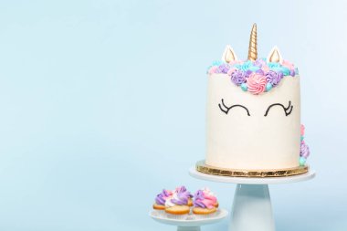 Pembe ve mor mavi arka plan üzerinde buzlanma buttercream ile gurme tek boynuzlu at pasta.