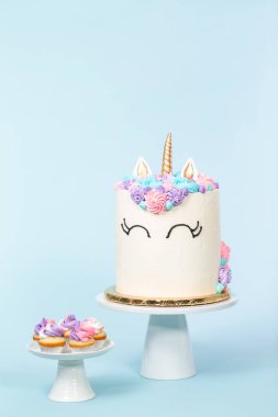 Pembe ve mor mavi arka plan üzerinde buzlanma buttercream ile gurme tek boynuzlu at pasta.