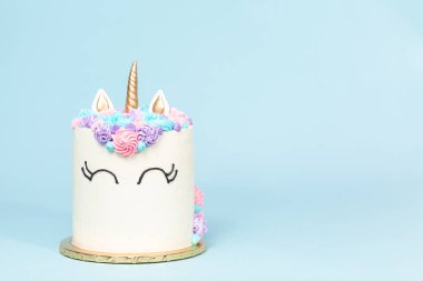 Pembe ve mor mavi arka plan üzerinde buzlanma buttercream ile gurme tek boynuzlu at pasta.