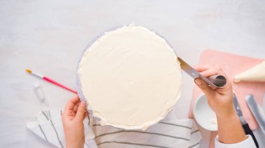 Düz yatıyordu. Beyaz buttercream buzlanma ile pembe ve mor pasta buzlanma.