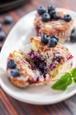 Ev yapımı blueberry muffins beyaz bir tabağa dilimlenmiş.