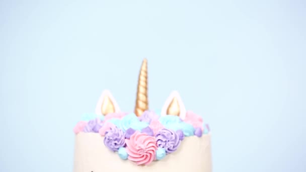 Gourmet Einhornkuchen Mit Rosa Und Lila Buttercreme Zuckerguss Auf Blauem — Stockvideo
