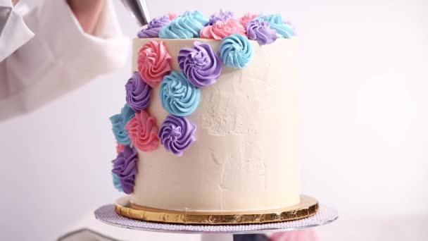 Baker Σωληνώσεις Παστέλ Χρώμα Buttercream Ρόδακες Ένα Άσπρο Κέικ Κάνει — Αρχείο Βίντεο