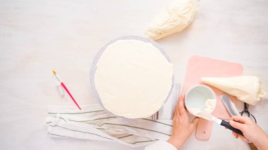 Düz yatıyordu. Beyaz buttercream buzlanma ile pembe ve mor pasta buzlanma.