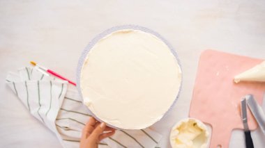 Düz yatıyordu. Beyaz buttercream buzlanma ile pembe ve mor pasta buzlanma.
