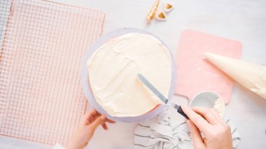 Düz yatıyordu. Beyaz buttercream buzlanma ile pembe ve mor pasta buzlanma.