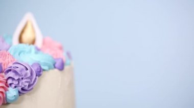 Pembe ve mor mavi arka plan üzerinde buzlanma buttercream ile gurme tek boynuzlu at pasta.