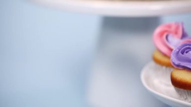 Pembe ve mor mavi arka plan üzerinde buzlanma buttercream ile gurme tek boynuzlu at pasta.