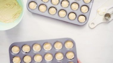 Düz yatıyordu. Cupcake gömlekleri içine vanilyalı kek hamuru scooping.