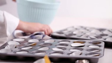 Cupcake gömlekleri içine vanilyalı kek hamuru scooping.