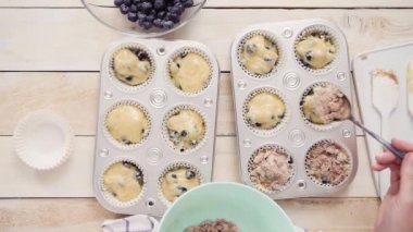 Tarçın ve şeker yaban mersinli kek hamuru üzerinde Tepesi scooping.