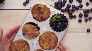 Blueberry muffins metal muffin pan dışarı alarak.