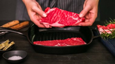 Dökme demir tavada ham New York şerit biftek.