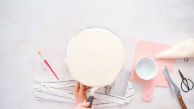 Düz yatıyordu. Beyaz buttercream buzlanma ile pembe ve mor pasta buzlanma.