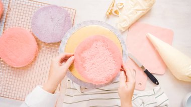 Düz yatıyordu. Yapmak için montaj pembe ve mor pasta katının tek boynuzlu at kek küçük kızın Doğum günü partisi için.