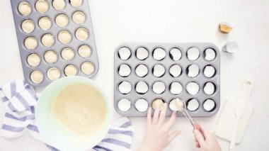 Düz yatıyordu. Cupcake gömlekleri içine vanilyalı kek hamuru scooping