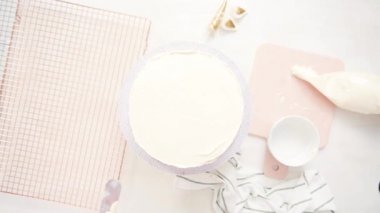 Düz yatıyordu. Beyaz buttercream buzlanma ile pembe ve mor pasta buzlanma