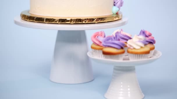 美食独角兽蛋糕与粉红色和紫色的奶油霜在蓝色背景 — 图库视频影像