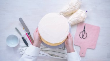 Düz yatıyordu. Beyaz buttercream buzlanma ile pembe ve mor pasta buzlanma.