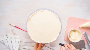 Düz yatıyordu. Beyaz buttercream buzlanma ile pembe ve mor pasta buzlanma.