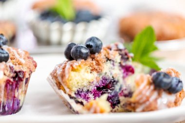 Ev yapımı blueberry muffins beyaz bir tabağa dilimlenmiş.