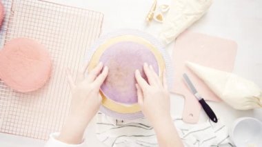 Düz yatıyordu. Yapmak için montaj pembe ve mor pasta katının tek boynuzlu at kek küçük kızın Doğum günü partisi için.