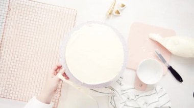 Düz yatıyordu. Beyaz buttercream buzlanma ile pembe ve mor pasta buzlanma.