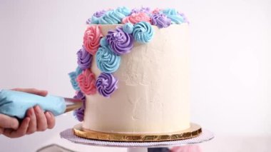 Baker boru pastel renk buttercream rozet beyaz bir pastayı tek boynuzlu at yapmak kek.