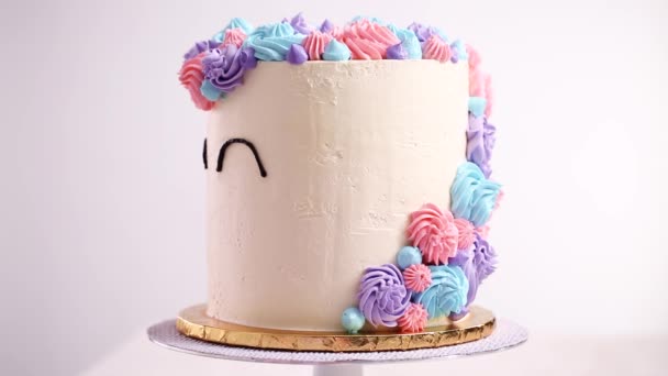 ユニコーンの目を白いケーキの上のアイシング黒 Buttercream と配管 — ストック動画