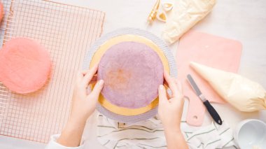 Düz yatıyordu. Yapmak için montaj pembe ve mor pasta katının tek boynuzlu at kek küçük kızın Doğum günü partisi için.