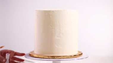 Bir tek boynuzlu at yapmak için beyaz bir pasta yemek glitter uygulama Baker'ın pasta.