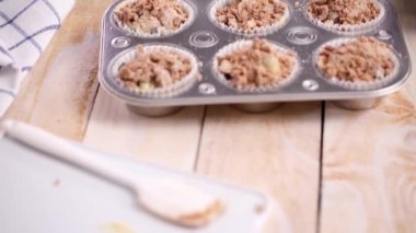 Yaban mersinli kek hamuru metal muffin tava içine scooping.