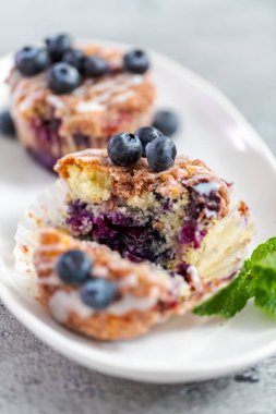 Ev yapımı blueberry muffins beyaz bir tabağa dilimlenmiş.