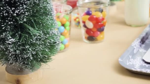 お菓子と小さなジンジャーブレッドの家を飾るために子供たちのパーティー — ストック動画