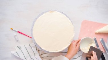 Düz yatıyordu. Beyaz buttercream buzlanma ile pembe ve mor pasta buzlanma.