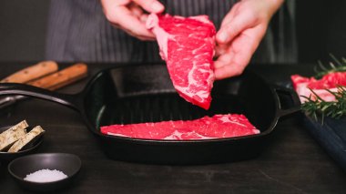 Dökme demir tavada ham New York şerit biftek.