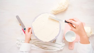 Düz yatıyordu. Beyaz buttercream buzlanma ile pembe ve mor pasta buzlanma.