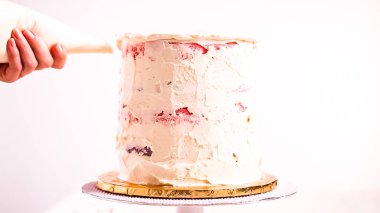 Beyaz buttercream buzlanma ile pembe ve mor pasta frosting Baker.